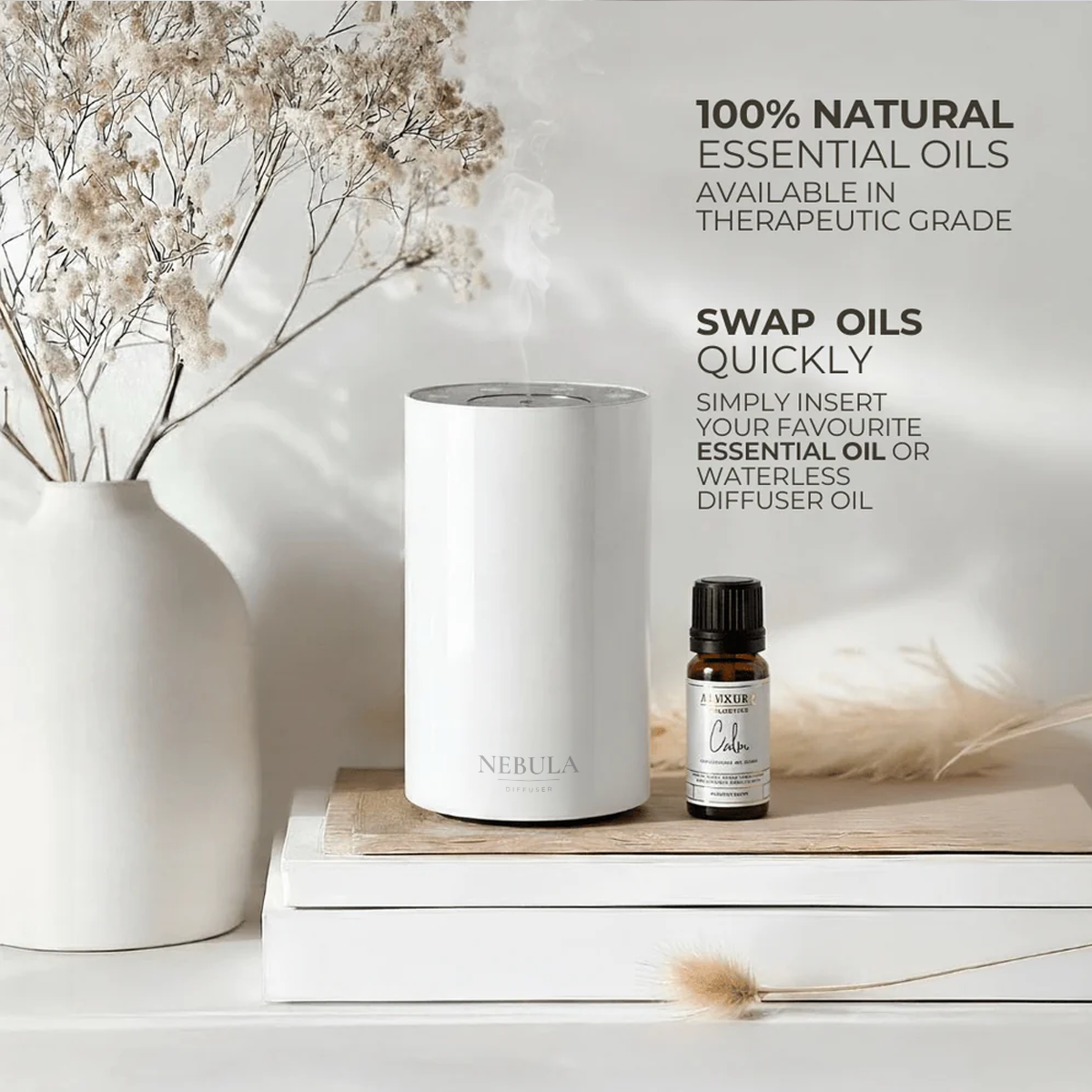 White waterless diffuser and essential oil bottle on a wooden surface with decorative elements.