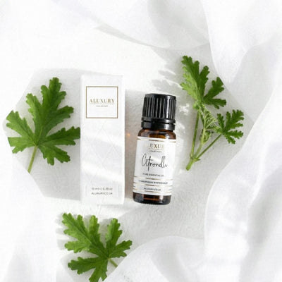 Citronella essential oil bottle and packaging on a white fabric background