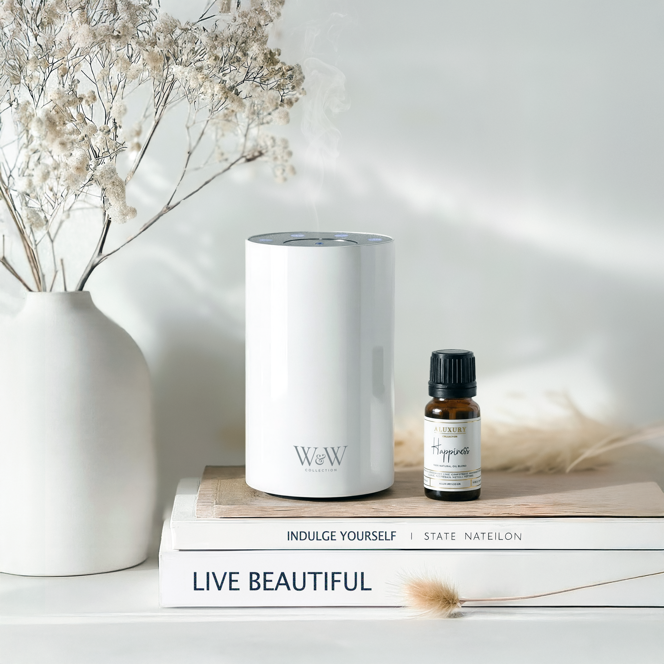 Nebula mini electric diffuser in white with Happiness essential oil bottle