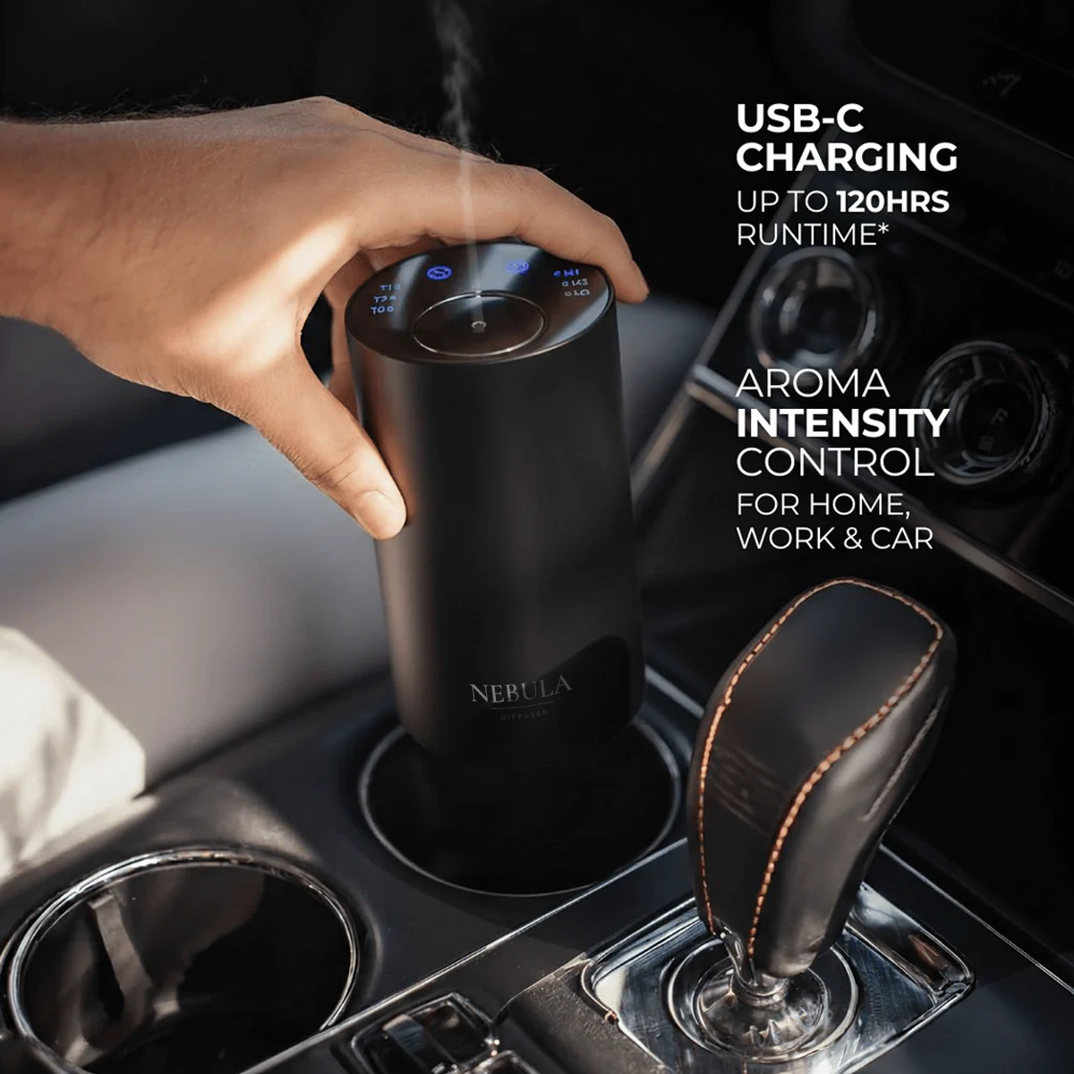 Hand holding a black wireless electronic diffuser in a car's cup holder with text about USB-C charging and aroma intensity control. 