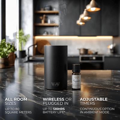 Black wireless diffuser and essential oil bottle on a kitchen counter with product features displayed. 