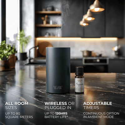 Grey wireless diffuser and essential oil bottle on a kitchen counter with product features displayed. 