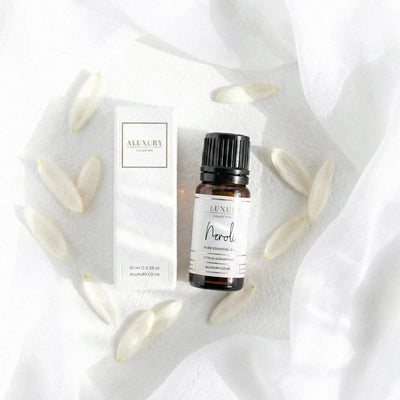 Neroli essential oil bottle and packaging on a white fabric background