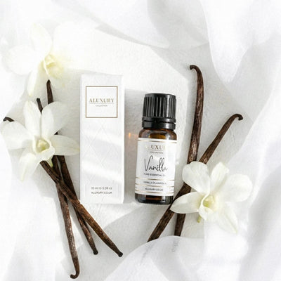 Aluxury vanilla essential oil bottle and packaging on a white fabric background